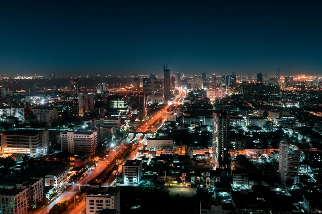 Explore the vibrant skyline of Bangkok with its illuminated skyscrapers and bustling streets captured at night.