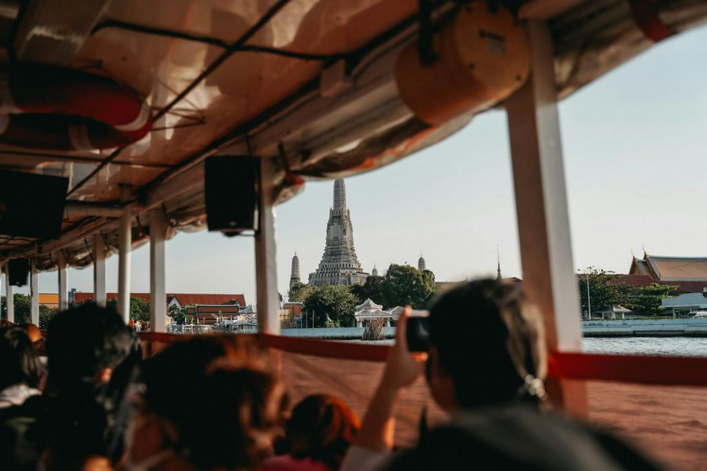 A scenic view of Wat Arun temple from a riverboat in Bangkok, capturing the essence of Thai culture.