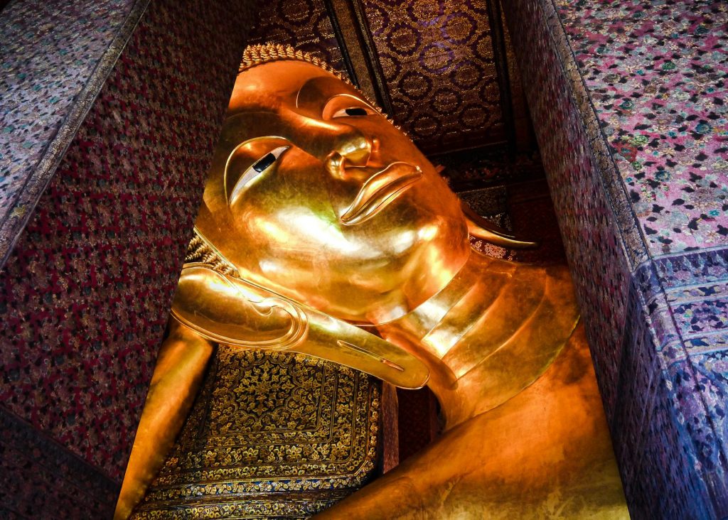 A majestic view of the golden reclining Buddha statue inside Wat Pho, Bangkok, Thailand.