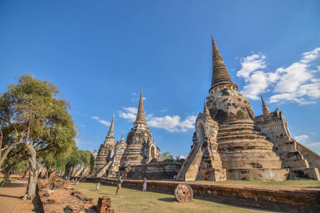 Explore the ancient pagodas of Ayutthaya Historical Park on a clear sunny day in Thailand.