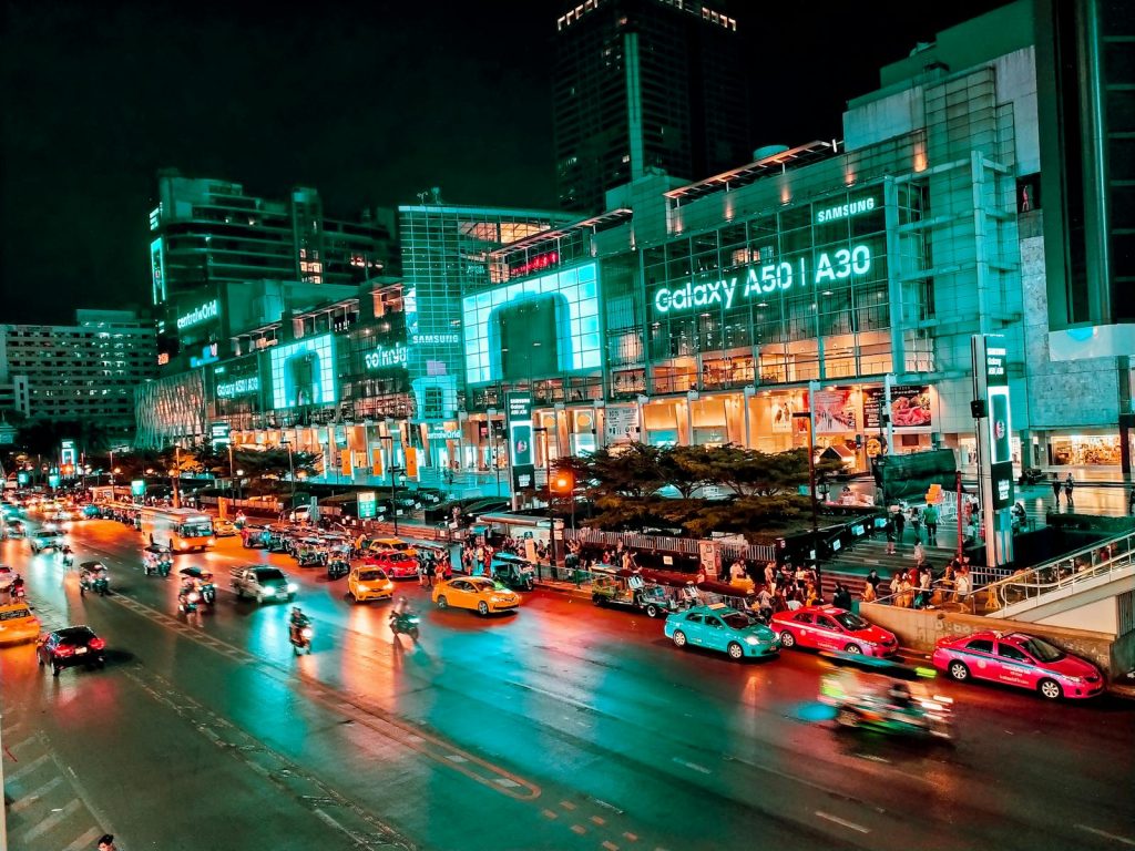 Explore the bustling nightlife of downtown Bangkok with vibrant city lights and busy streets.