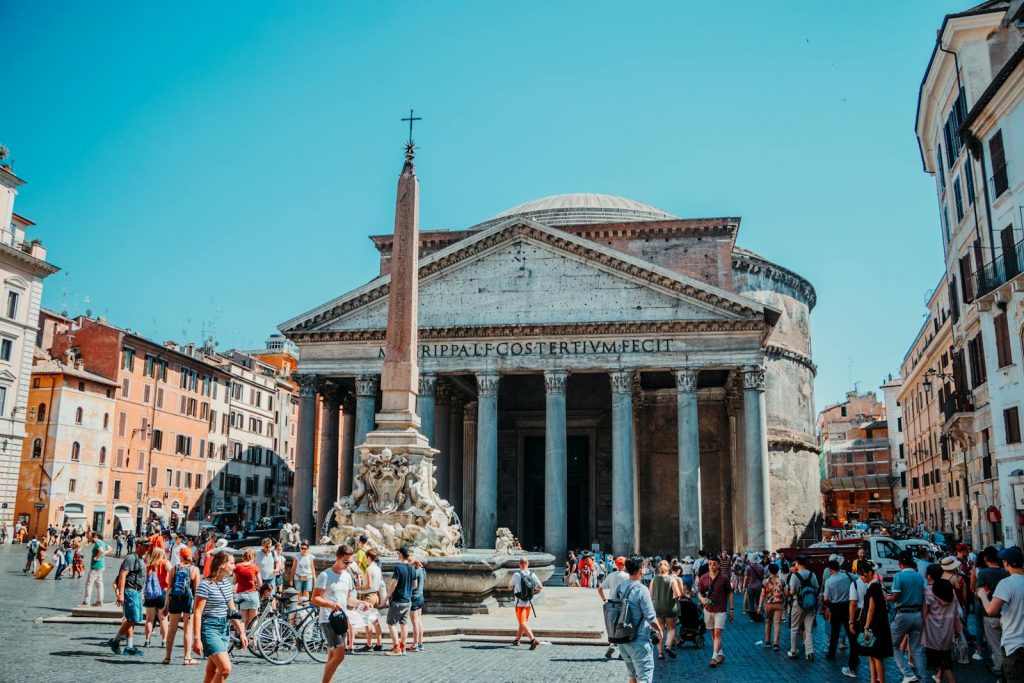 Tourists explore the iconic Pantheon in Rome, Italy on a sunny day.