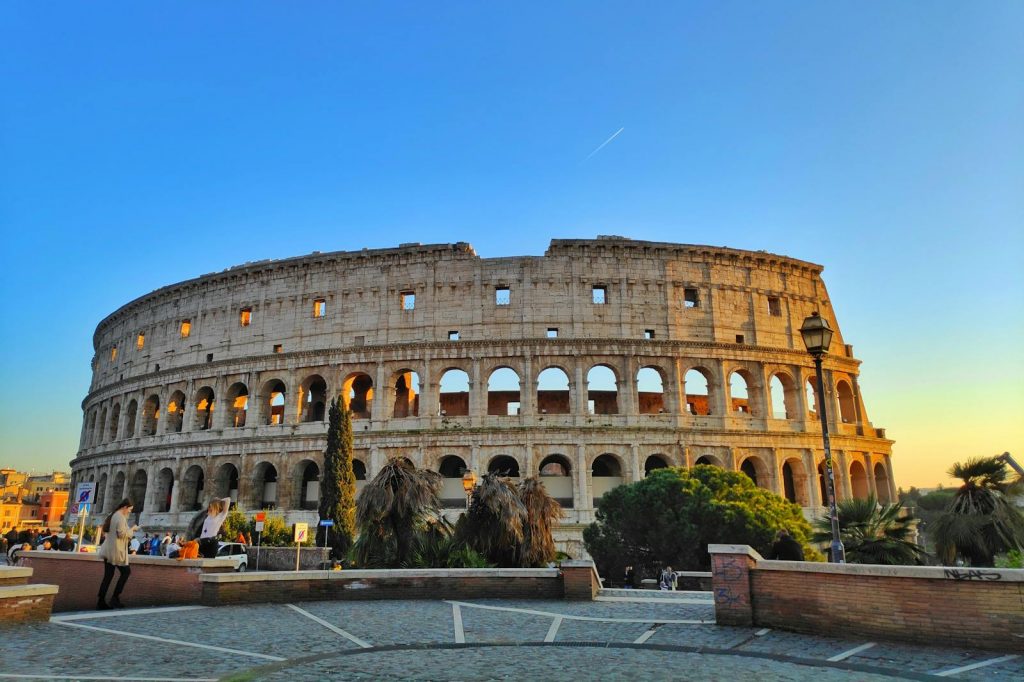 Vibrant image of the Roman Colosseum at sunset, capturing its historic architecture in Rome, Italy.