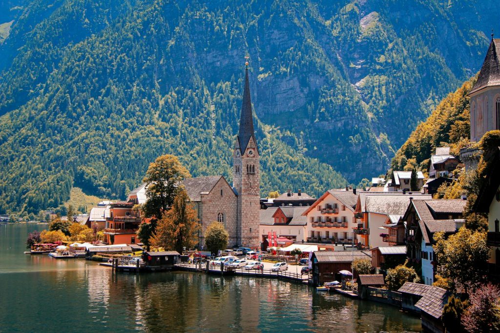 Picturesque view of Hallstatt, Austria with a prominent church by the waterfront, surrounded by mountains.