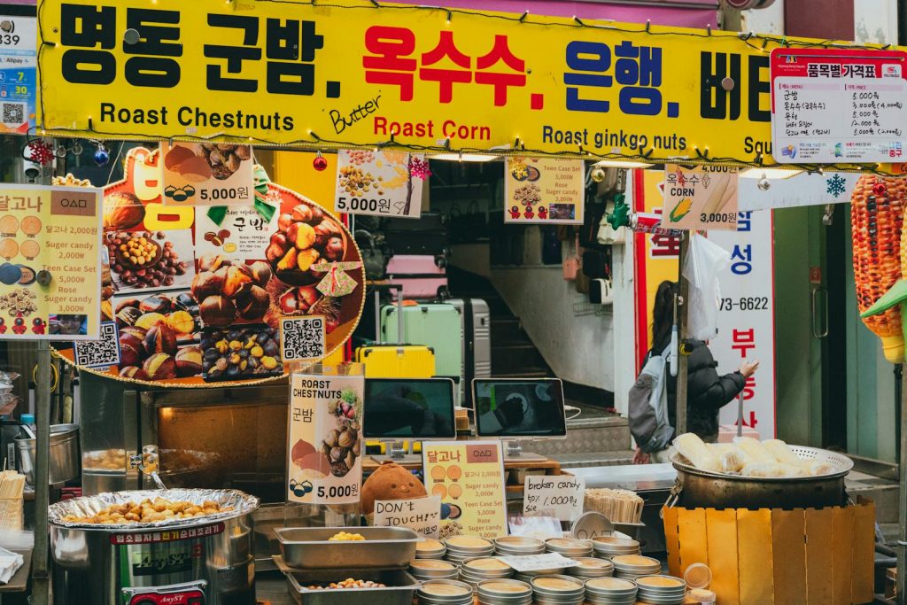 Lively street market stall selling roast chestnuts and corn in Seoul, South Korea, showcasing Korean street food culture.