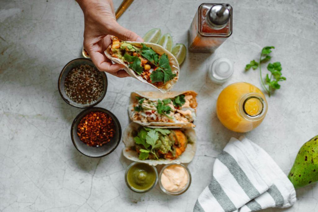 Appetizing Mexican tacos with colorful ingredients and sauces in a top view setting.