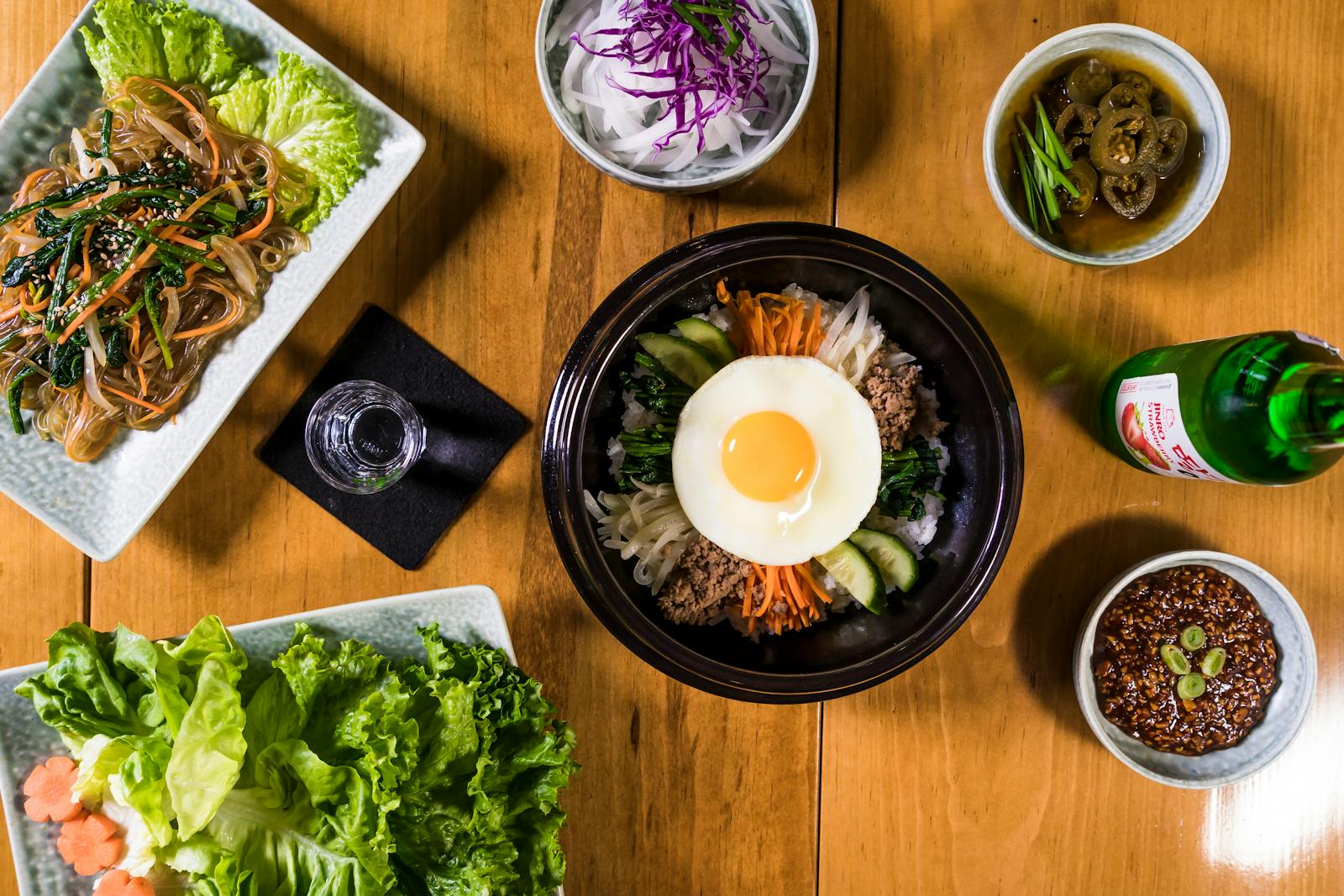 Authentic Korean meal featuring Bibimbap and Japchae, styled in a beautiful flat lay.