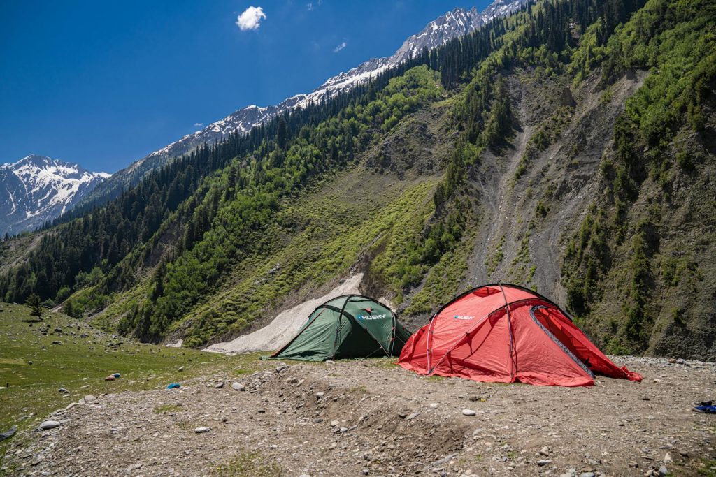 Picturesque campsite near Sonamarg, featuring vibrant tents against majestic mountain landscapes.