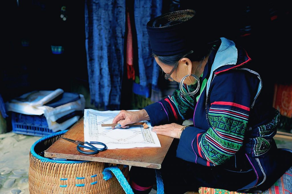 A Hmong woman skillfully creates traditional handicrafts in Lao Cai, showcasing cultural heritage.