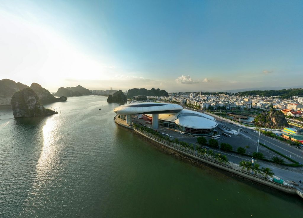A stunning aerial view of modern architecture against the scenic Ha Long Bay at sunset in Vietnam.