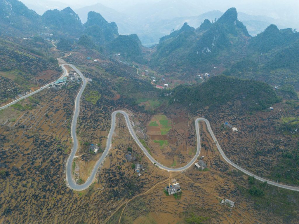 Aerial view of a winding mountain road in Ha Giang, Vietnam, showcasing stunning landscapes.