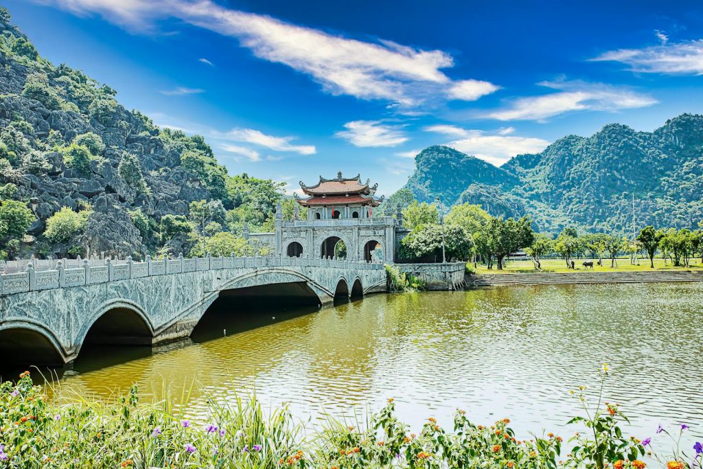 Explore the stunning landscape of Ninh Binh with its iconic bridge, temple, and natural beauty.