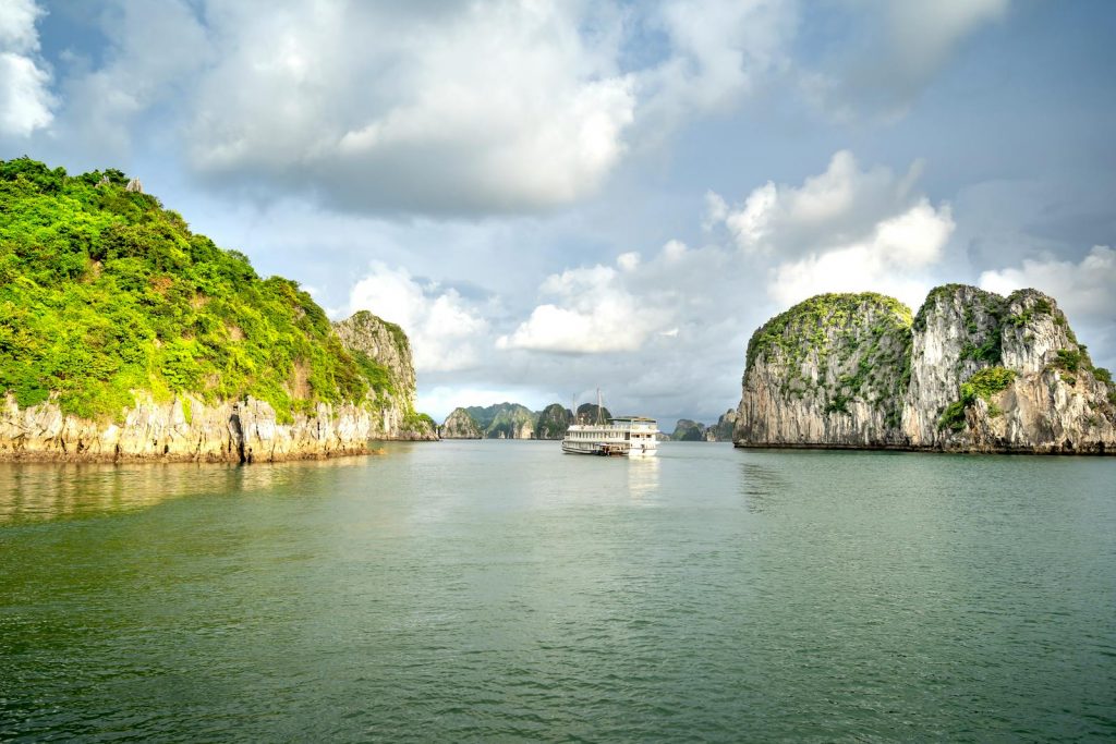 Discover the tranquil beauty of Halong Bay, featuring limestone karsts and a serene cruise ship.