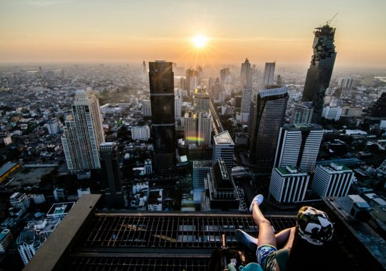 a person sitting on a ledge overlooking a city