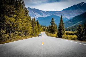 A scenic drive through the Rocky Mountains with a winding road and pine trees.