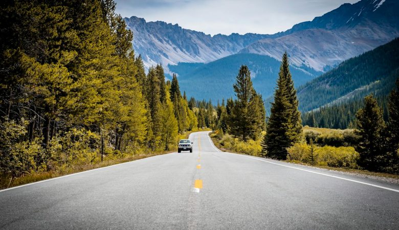 A scenic drive through the Rocky Mountains with a winding road and pine trees.