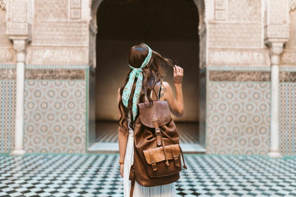 A woman in Marrakesh exploring the medina with a leather backpack, capturing the spirit of travel and adventure.