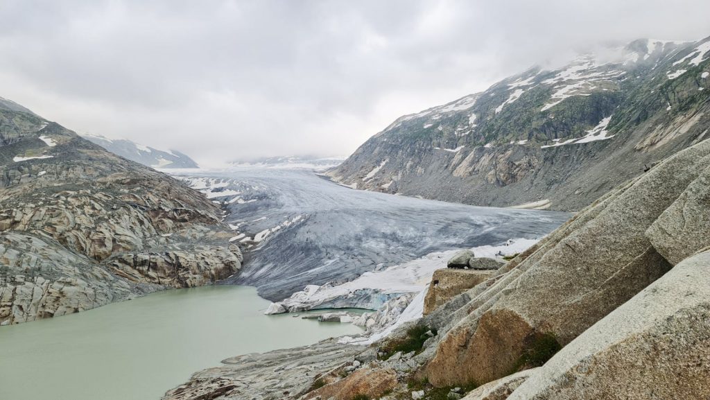 Explore the stunning glacier landscape with snow-capped mountains under a cloudy sky.