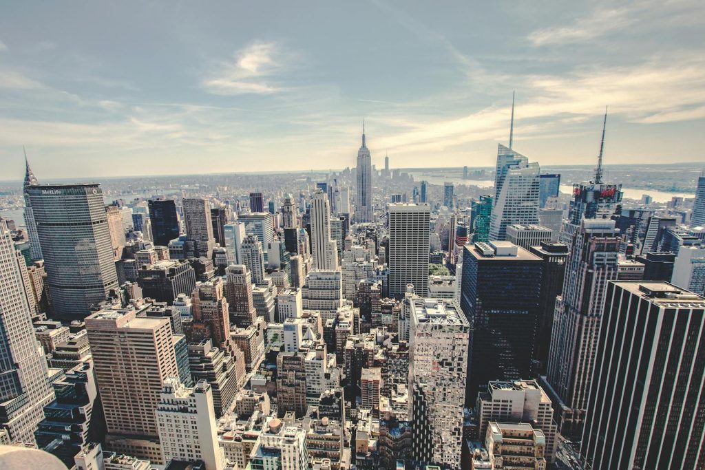 Aerial view of the iconic New York City skyline showcasing skyscrapers under a clear blue sky.