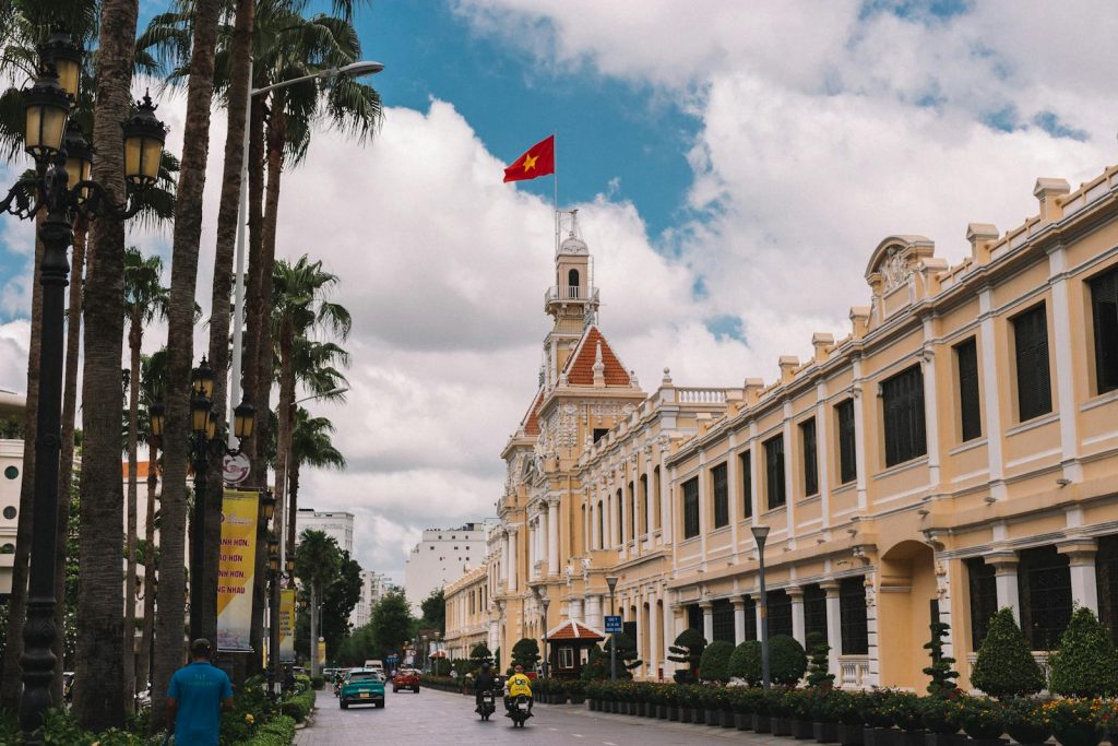 Charming street view of Ho Chi Minh City Hall with Vietnamese flag.
