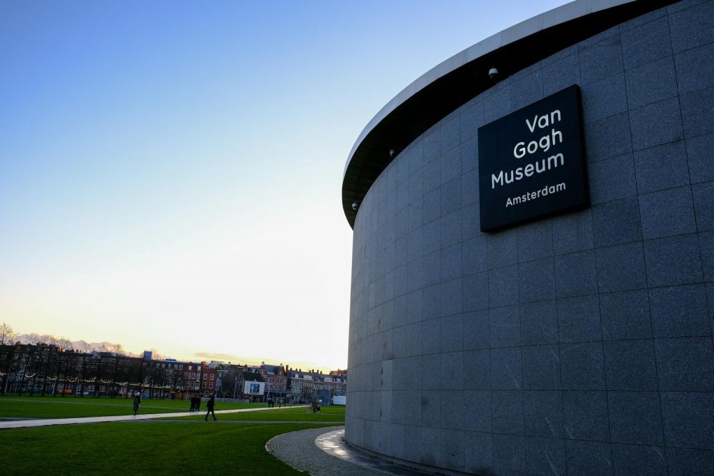 Exterior view of Van Gogh Museum in Amsterdam with blue sky and green park.