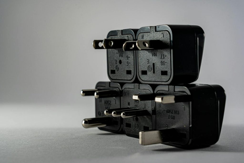 Close-up of black electrical adapters stacked on a gray background.