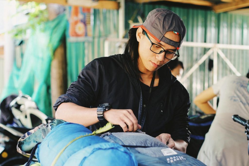 A young man packs his gear for an outdoor adventure, capturing a moment of preparation.