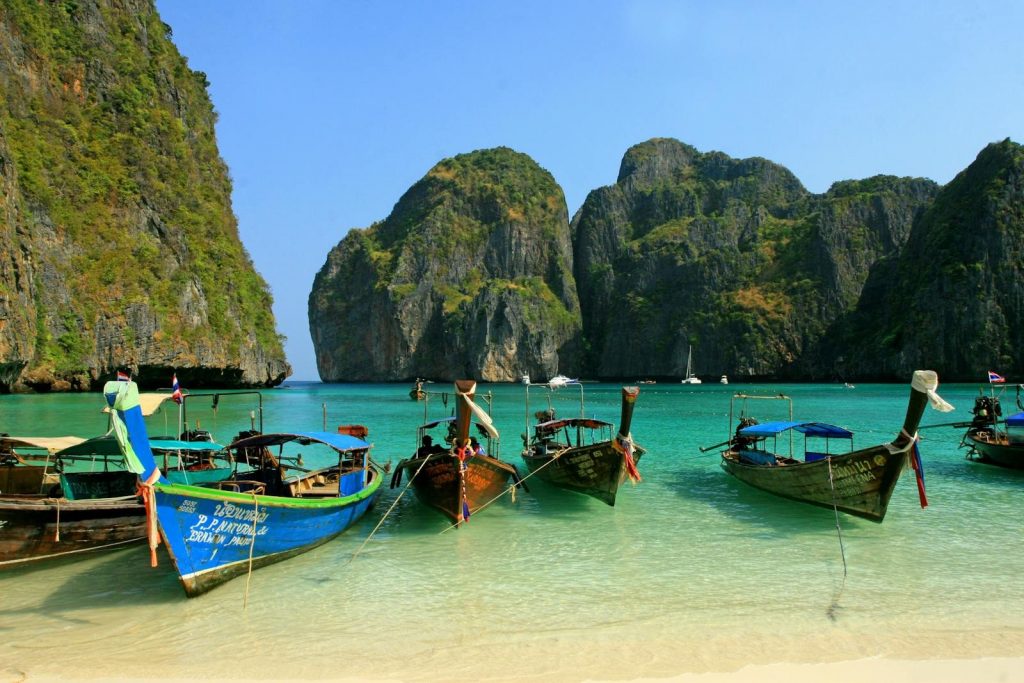Colorful longtail boats anchored at picturesque Maya Bay, a tropical paradise in Thailand.