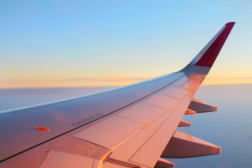 Beautiful view from an airplane wing against a sunset sky, creating a tranquil travel moment.