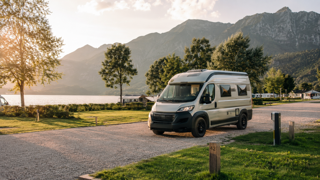 Wohnmobil auf einem Campingplatz am See mit Bergen